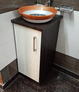 A small wooden white and brown cupboard with an attached sink is placed in a dining hall of a home