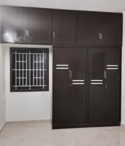 A warmly highlighted space with a window, two PVC cabinets, and black storage compartments